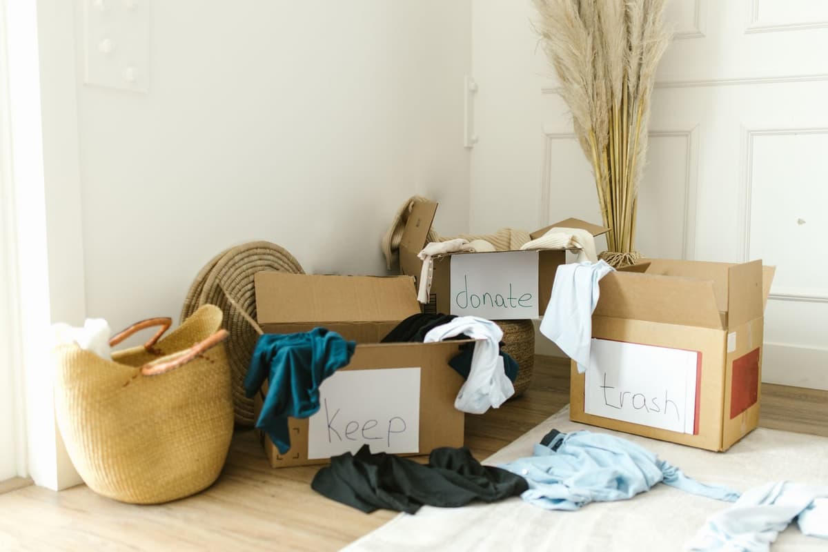 Labeled keep, donate, and trash boxes during a home declutter